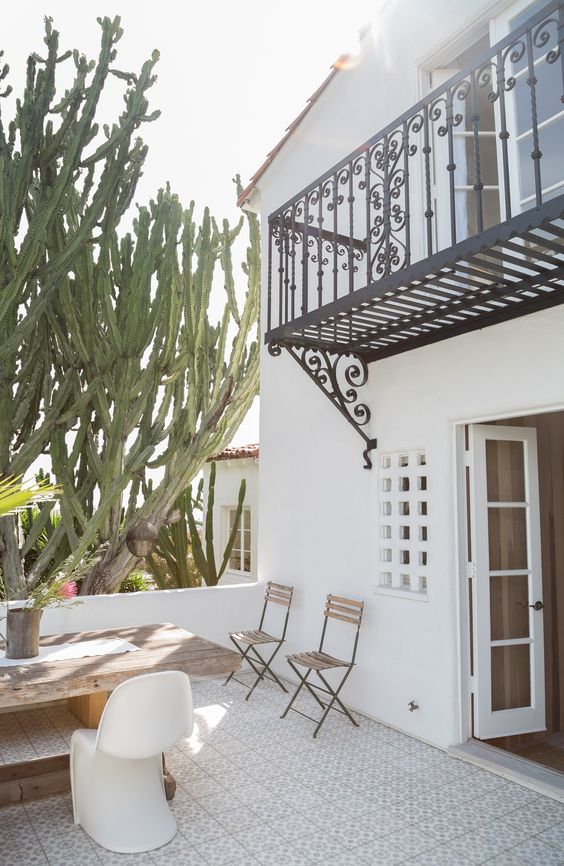 Spanish Colonial Style: Get Inspired By This Timeless Design Spanish colonial style garden with wrought iron gates, trellises, and decorative accents