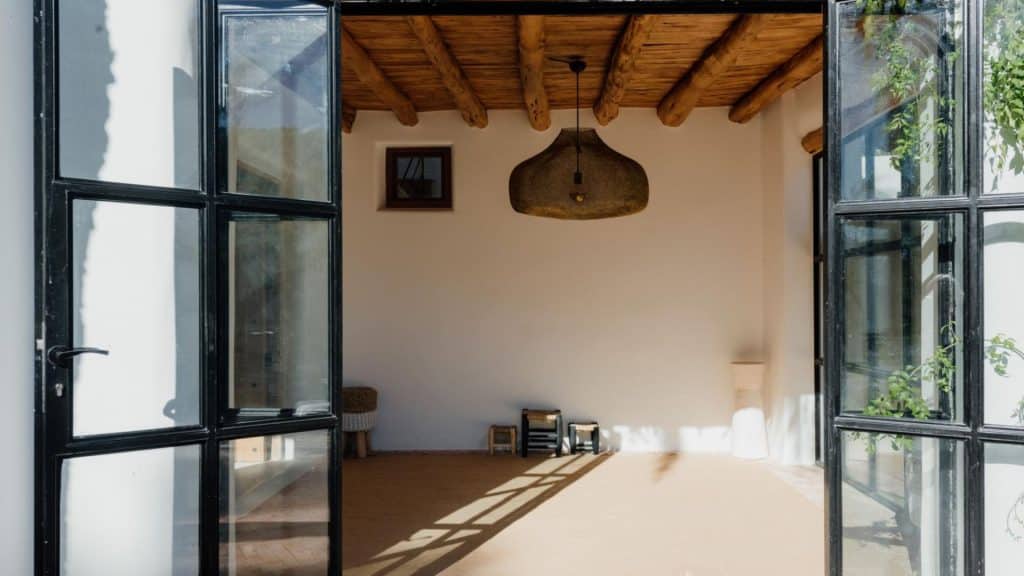The hanging bell-shaped light fixture adds a rustic charm to the modern design, suggesting that the villa's decor is a thoughtful blend of traditional and contemporary styles
